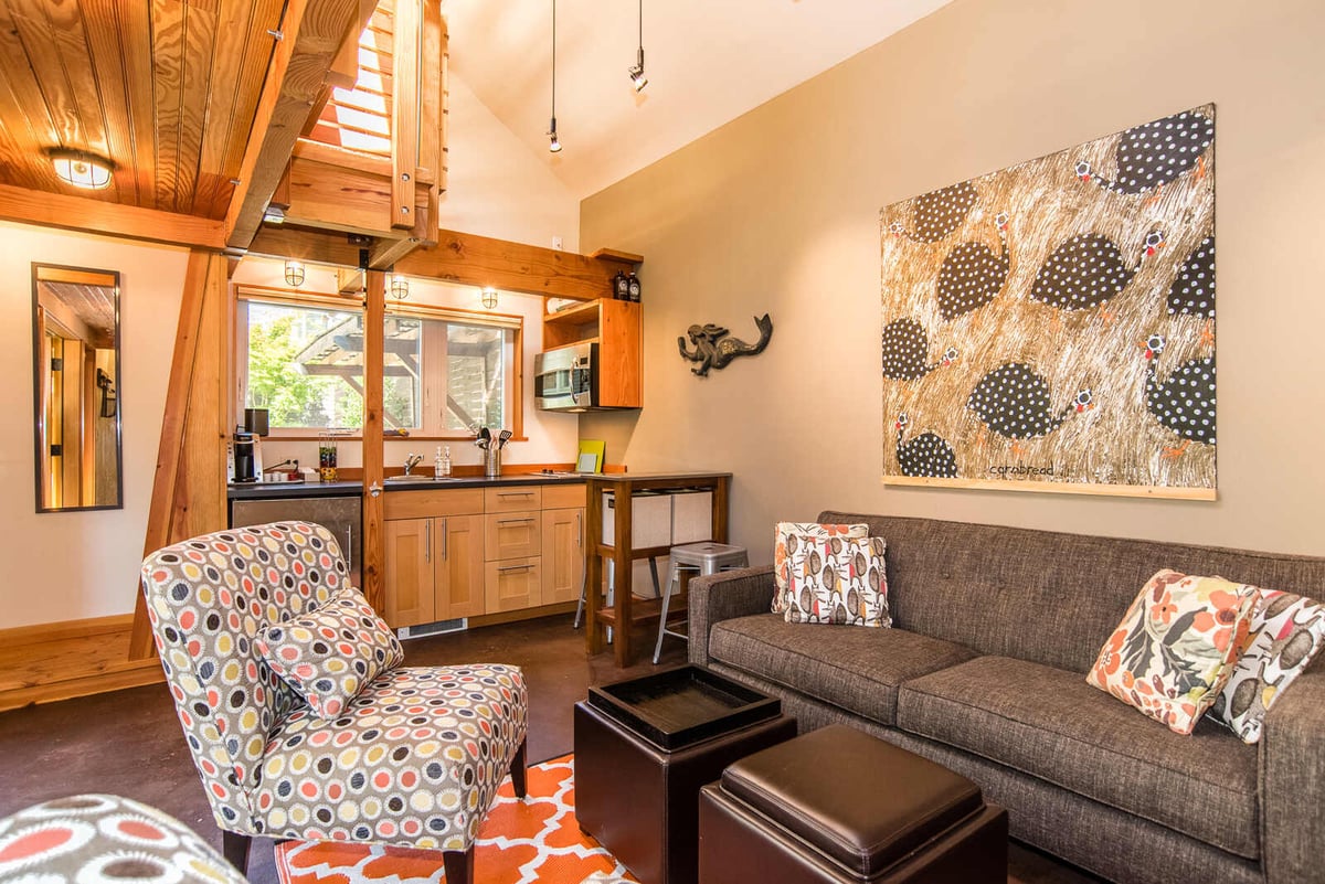 Cozy living room in an ADU featuring a modern couch, vibrant chairs, and wood accents, remodeled by CB Construction in Seattle