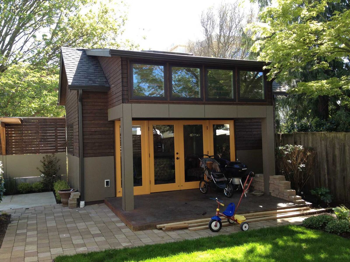 Exterior of a remodeled ADU with a tricycle and stroller on the patio, by CB Construction in Seattle