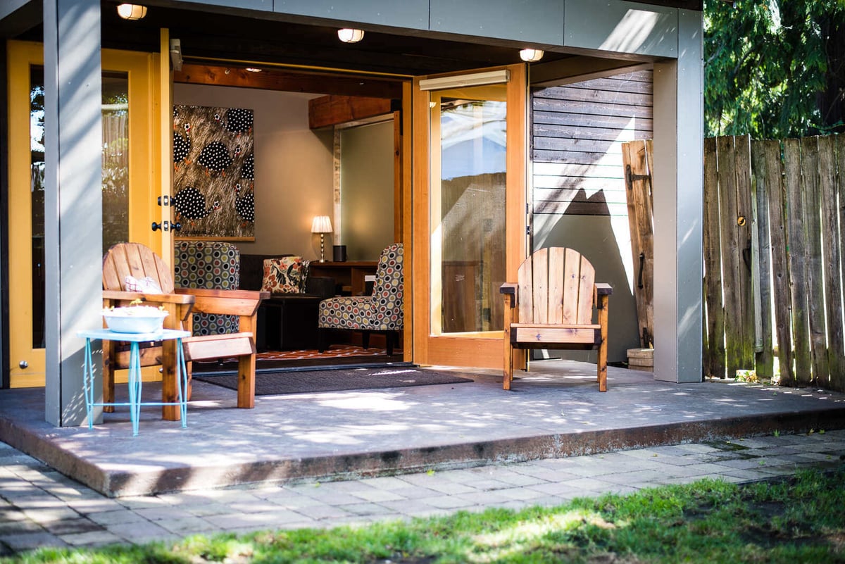 Exterior of an ADU with wooden chairs and patio space, remodeled by CB Construction in Seattle