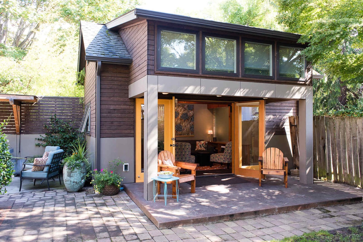 Exterior view of a remodeled ADU with large windows and open patio doors, by CB Construction in Seattle