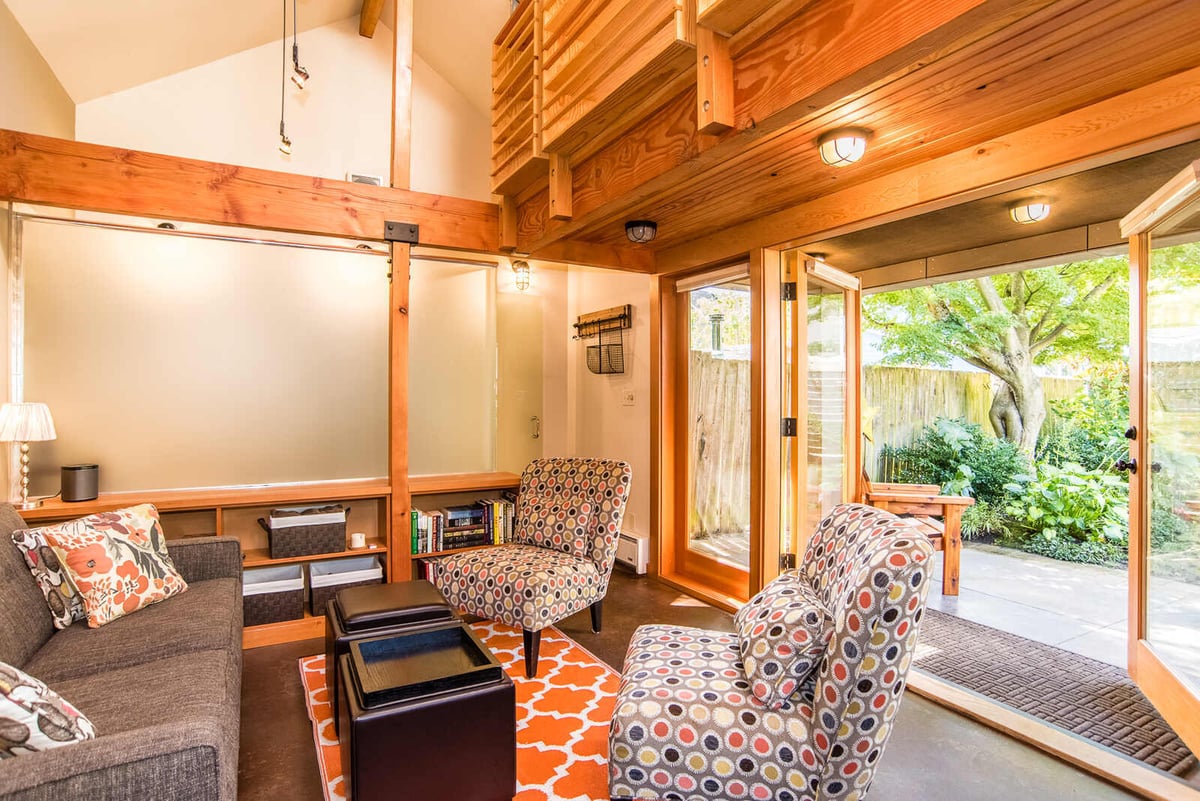 Inviting ADU living room with colorful seating and open patio doors, remodeled by CB Construction in Seattle