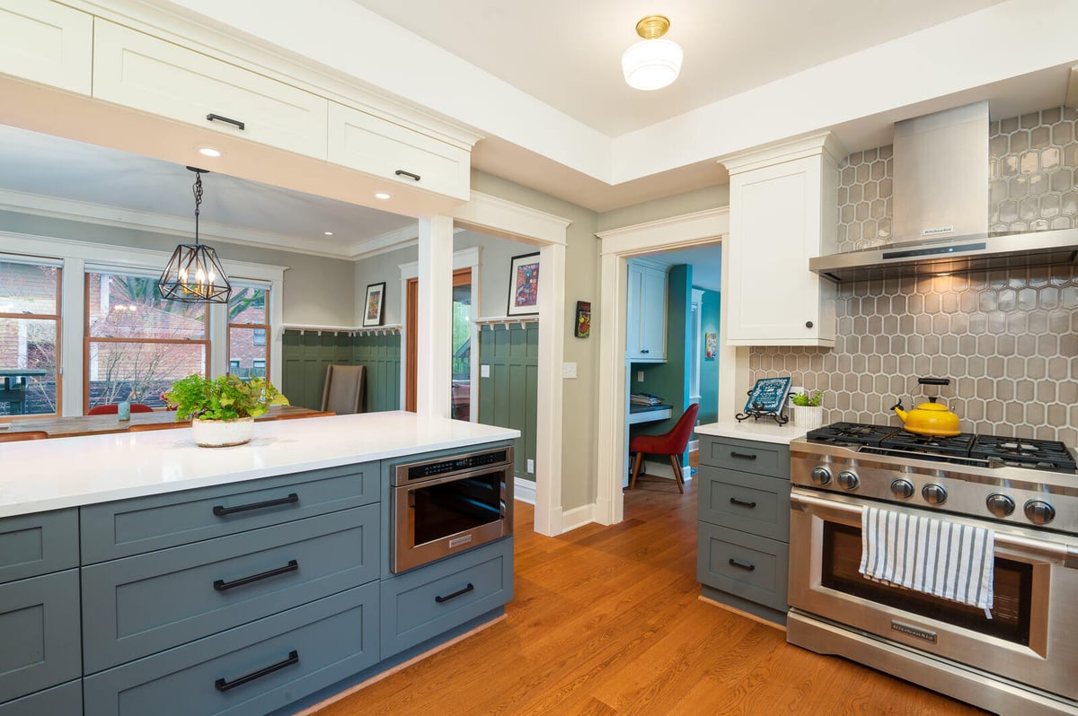 Bright kitchen remodel by CB Construction in Seattle with hexagonal backsplash and stainless steel appliances