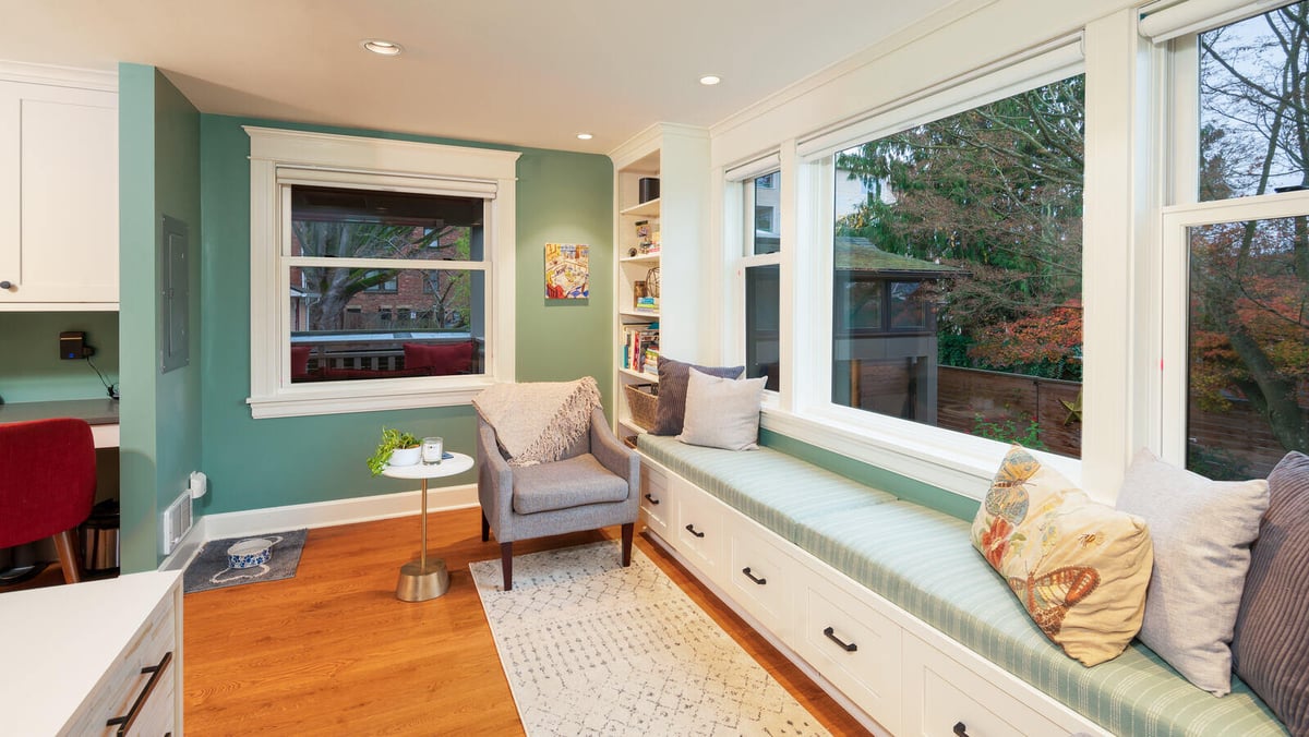 Cozy reading nook with built-in bench seating and large windows in a Seattle home remodeled by CB Construction