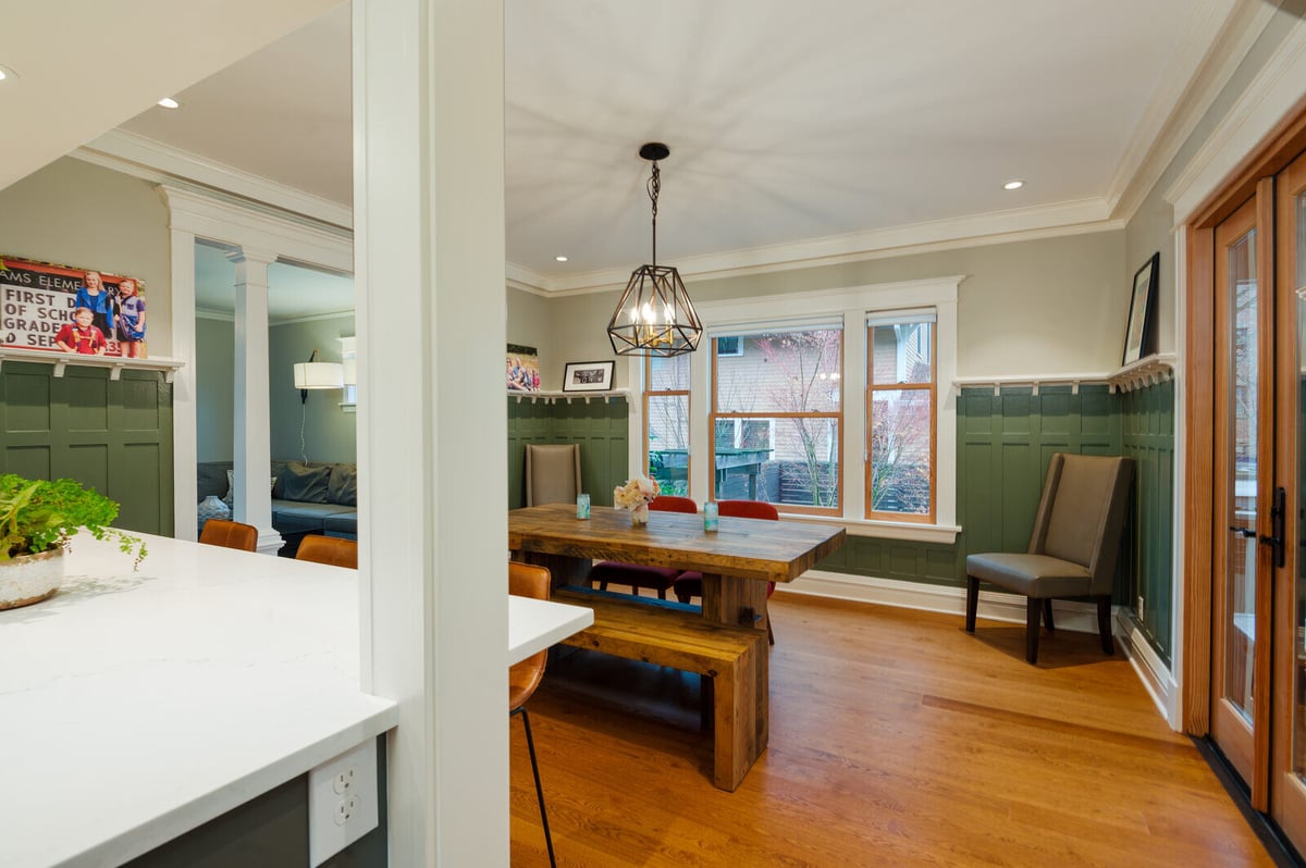 Dining area with wooden table and modern pendant light in a Seattle remodel by CB Construction