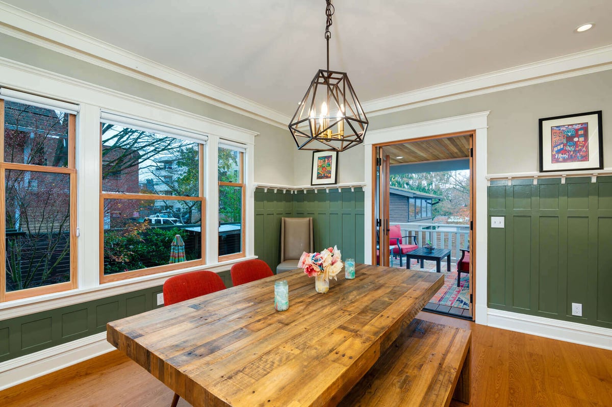 Inviting dining room with a large wooden table and red chairs by CB Construction in Seattle