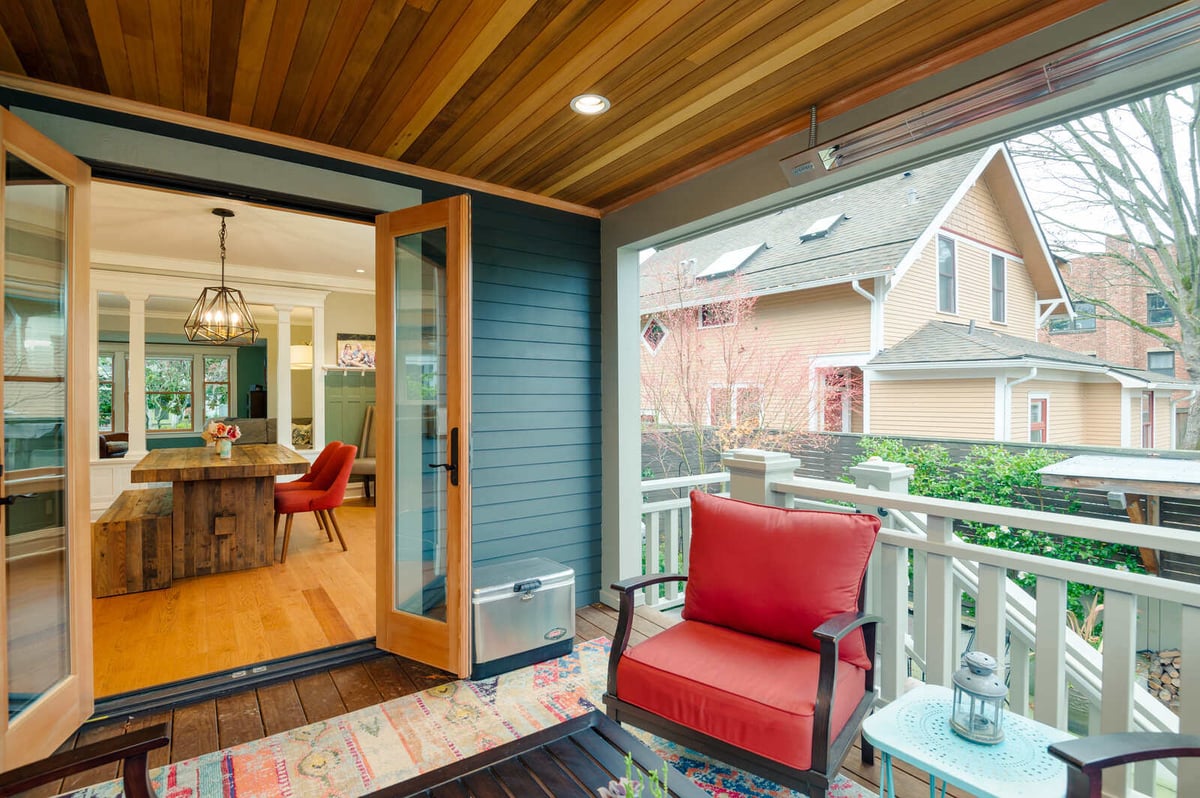 Open dining space with a large wooden table and pendant lighting by CB Construction in Seattle