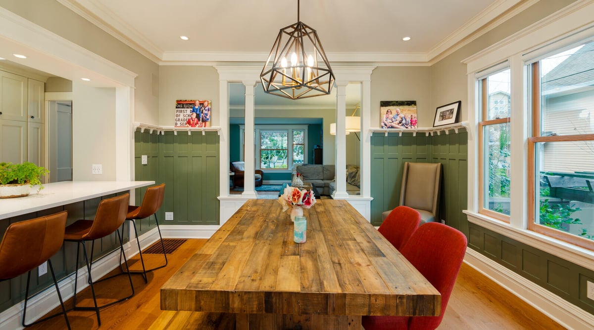 Seattle dining area with large wooden table and modern lighting by CB Construction