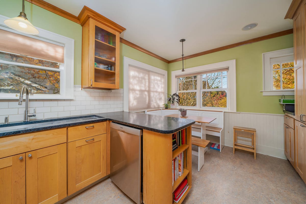 Bright Seattle kitchen with island seating and large windows by CB Construction