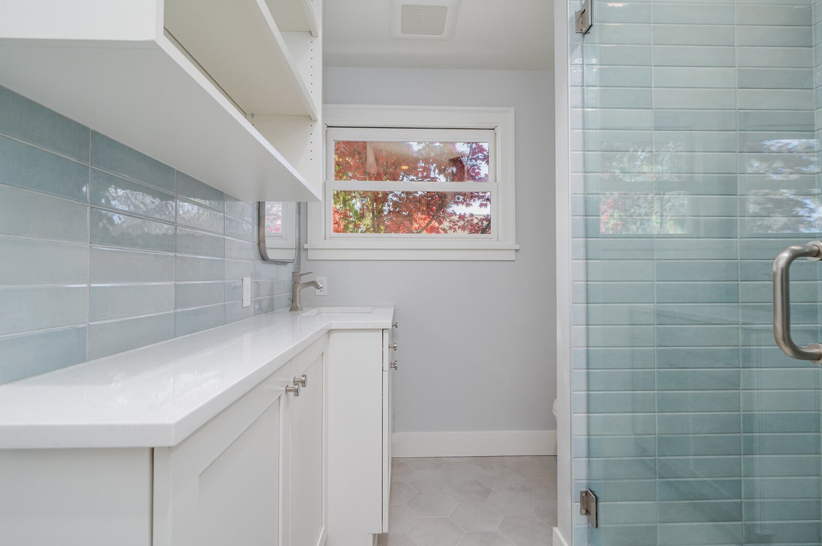 Custom laundry room with blue tile accents and storage, part of a CB Construction remodel in Seattle