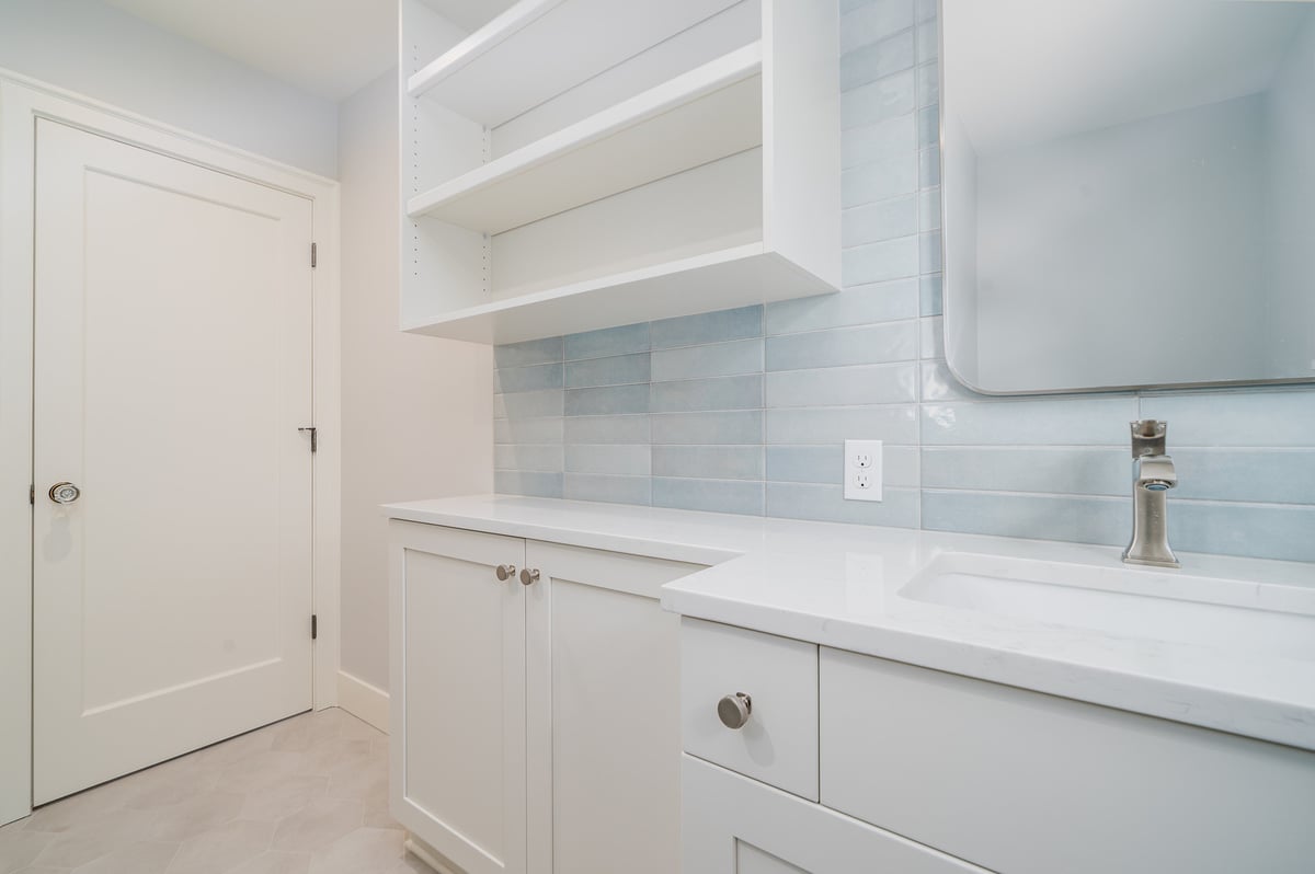 Custom-built storage and sink area in a remodeled laundry room by CB Construction, Seattle