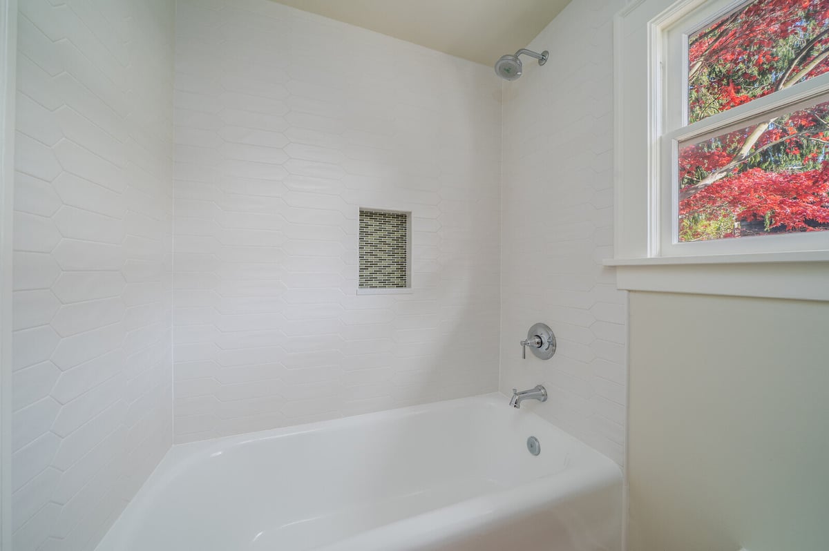 Modern bathroom remodel with white tile and built-in shower niche by CB Construction in Seattle