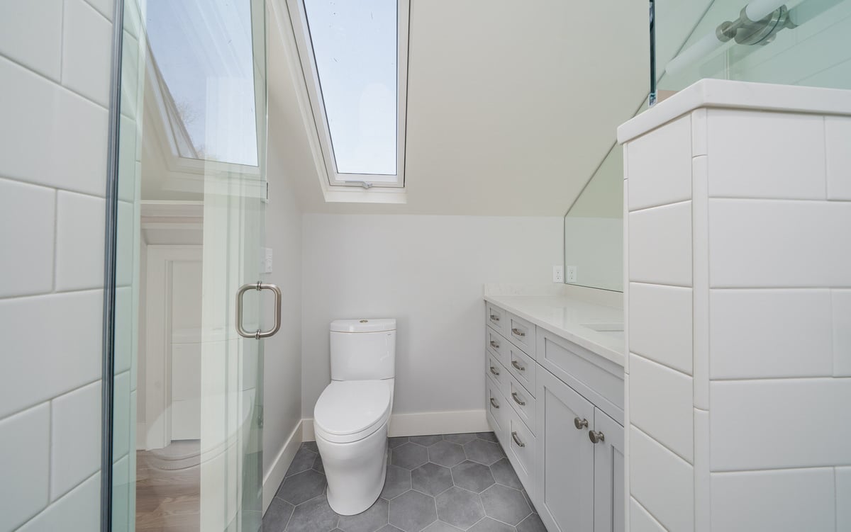 Modern bathroom with skylight and sleek fixtures in a whole home remodel by CB Construction, Seattle