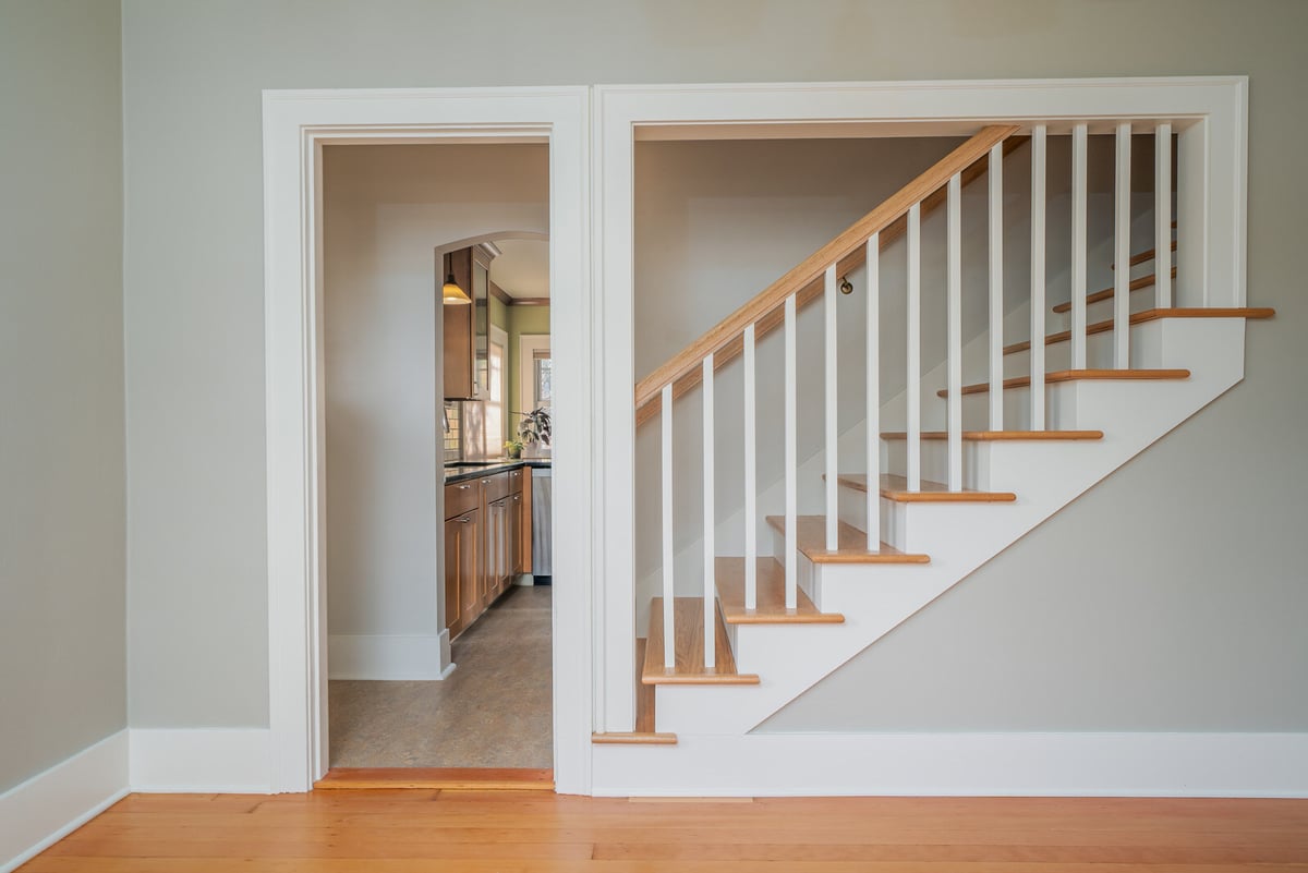 Open stairway with wooden steps leading to a kitchen, remodeled by CB Construction in Seattle