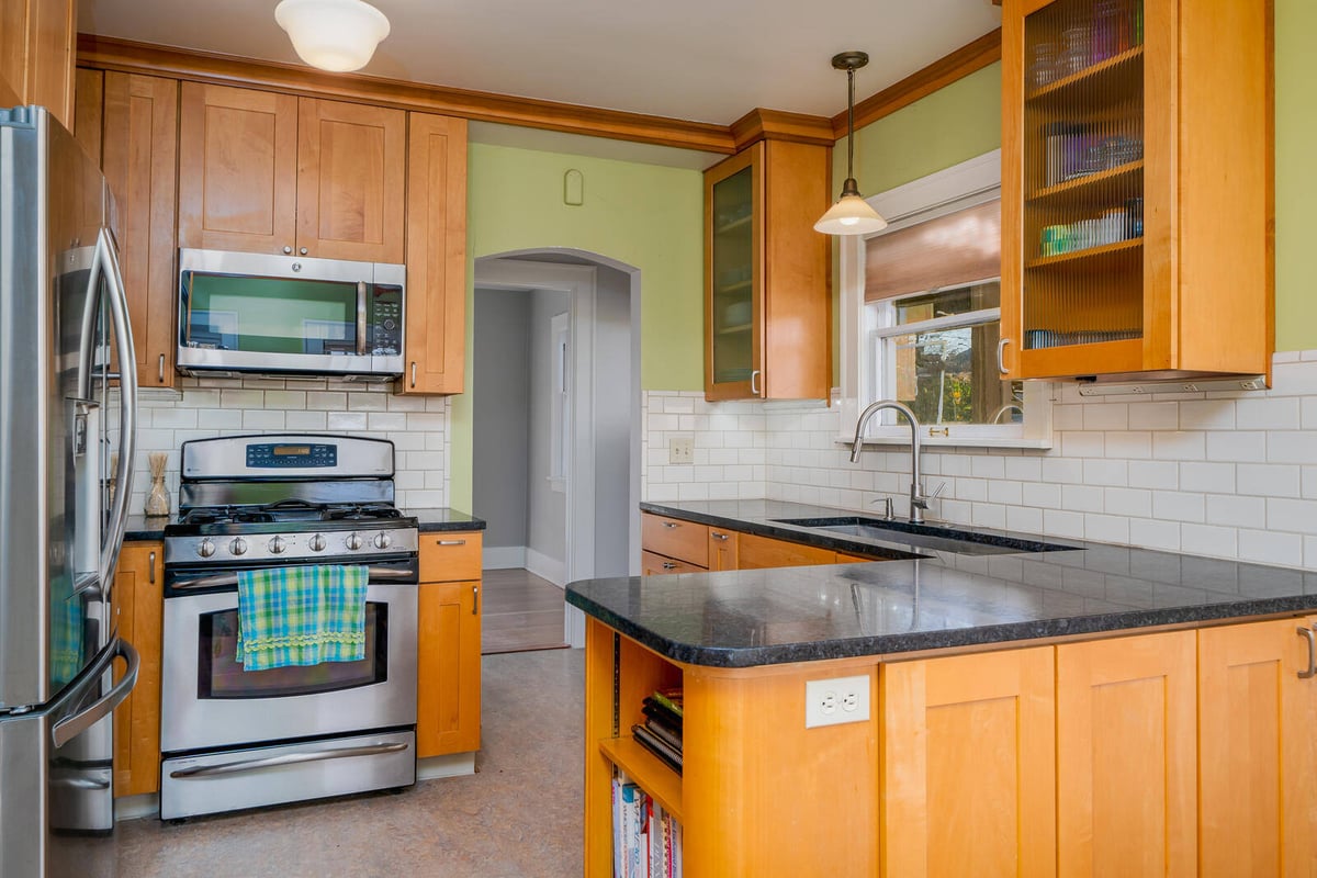 Renovated kitchen with wood cabinetry and stainless steel appliances by CB Construction in Seattle