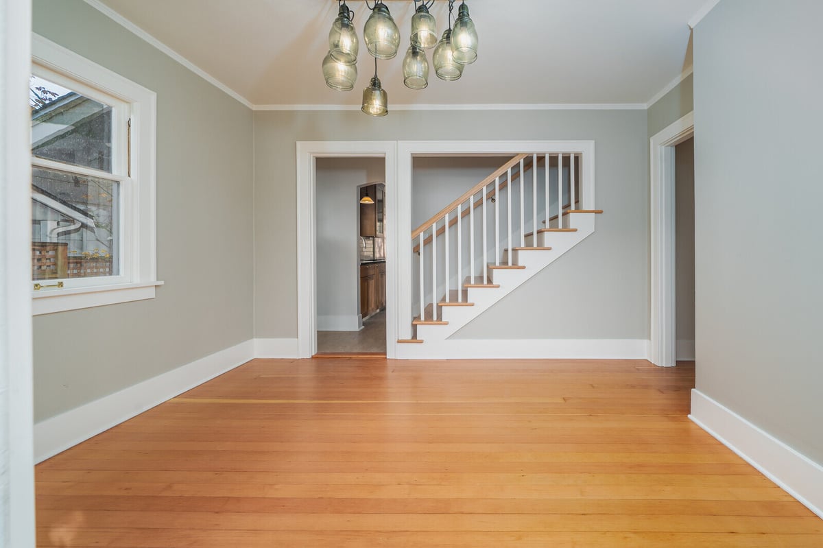 Spacious dining area with hardwood floors and staircase, part of a CB Construction renovation in Seattle