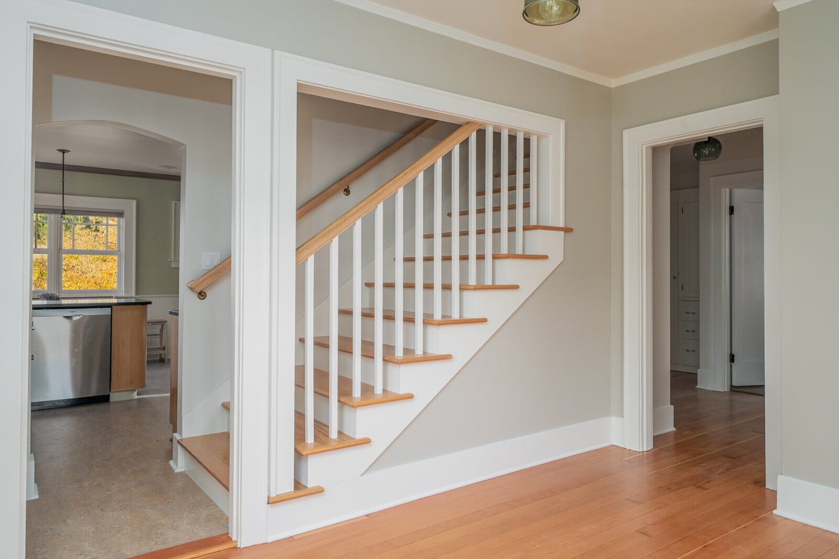 Updated staircase with white spindles in a Seattle home by CB Construction