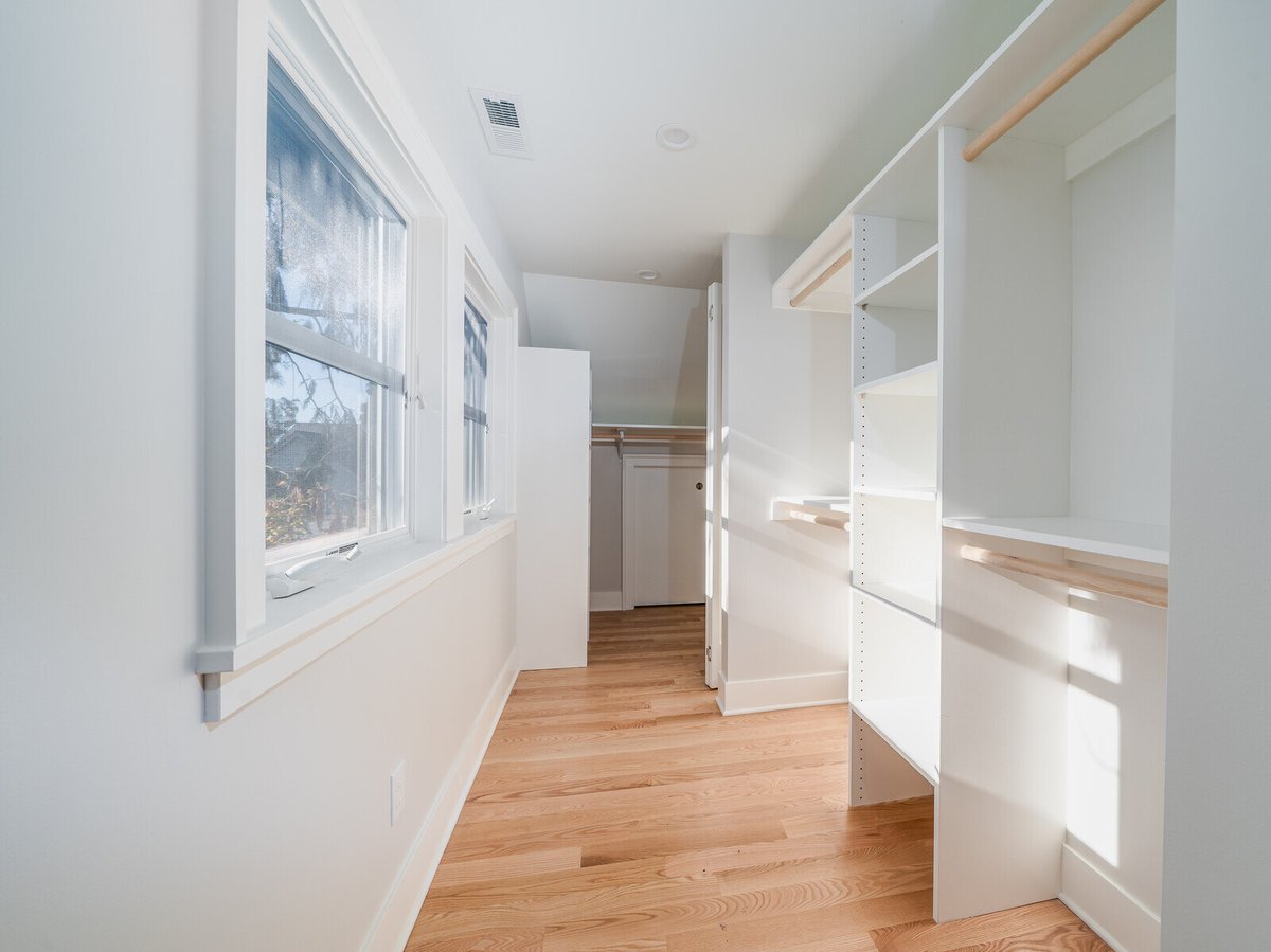 Walk-in closet with custom shelving and windows in a Seattle home, remodeled by CB Construction
