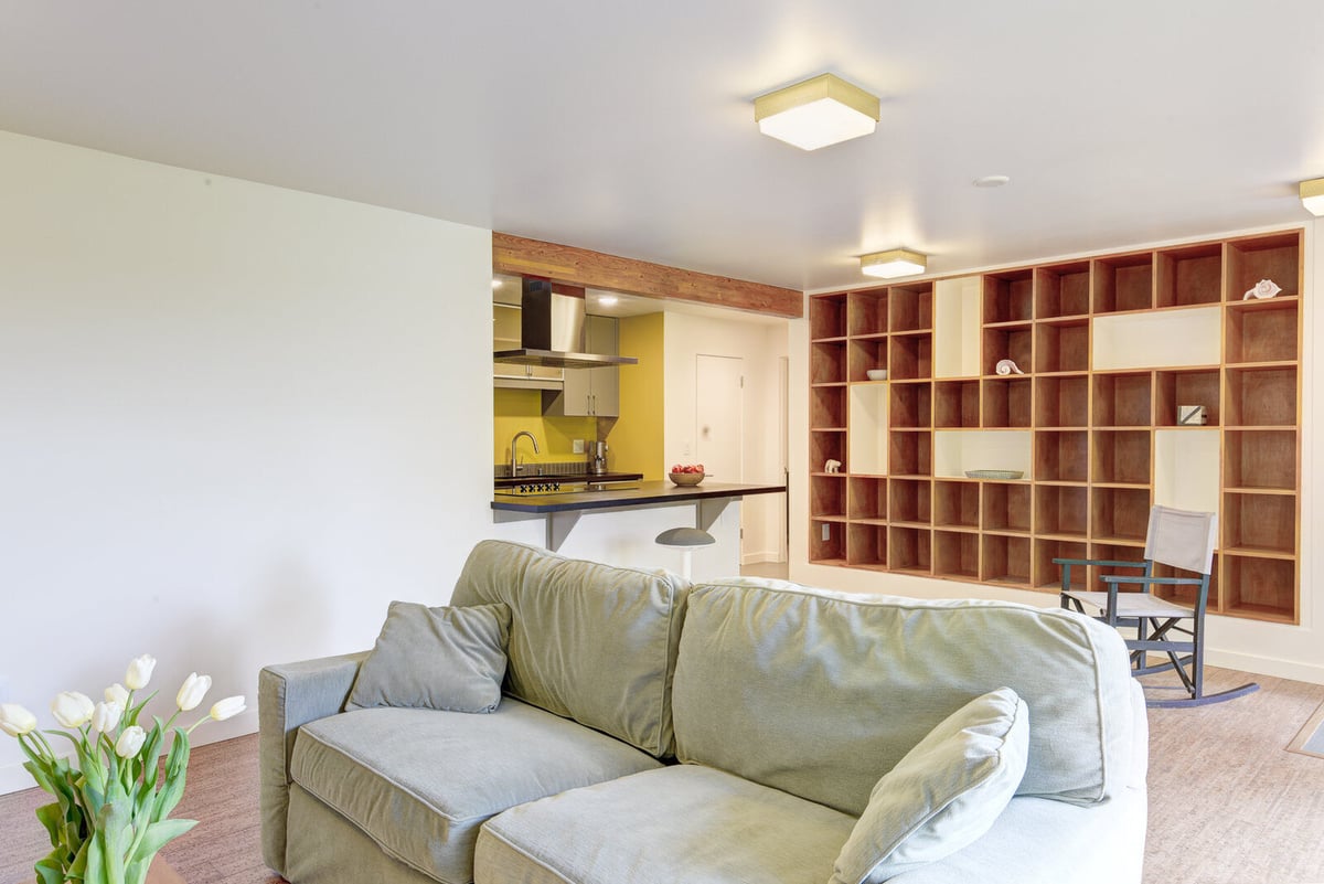 Modern basement ADU kitchen with built-in shelving and green accents, remodeled by CB Construction in Seattle.