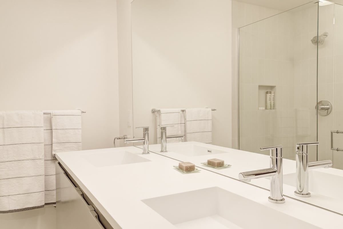 Modern bathroom with a double vanity and glass shower in a Seattle basement ADU, remodeled by CB Construction