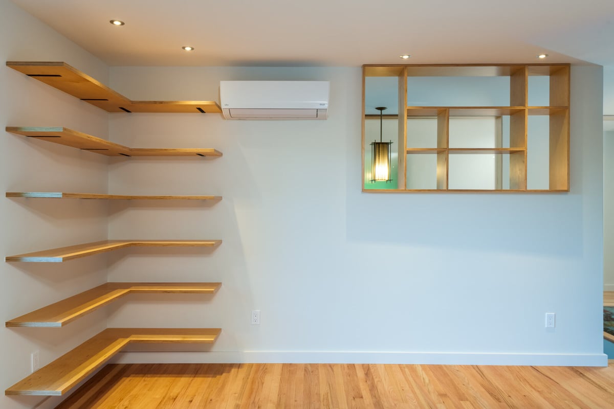Living room with wood-paneled fireplace and floating shelves, CB Construction, Seattle