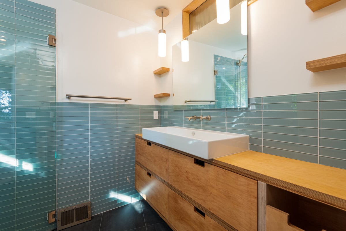 Main floor bathroom with glass shower and minimalist design by CB Construction in Seattle