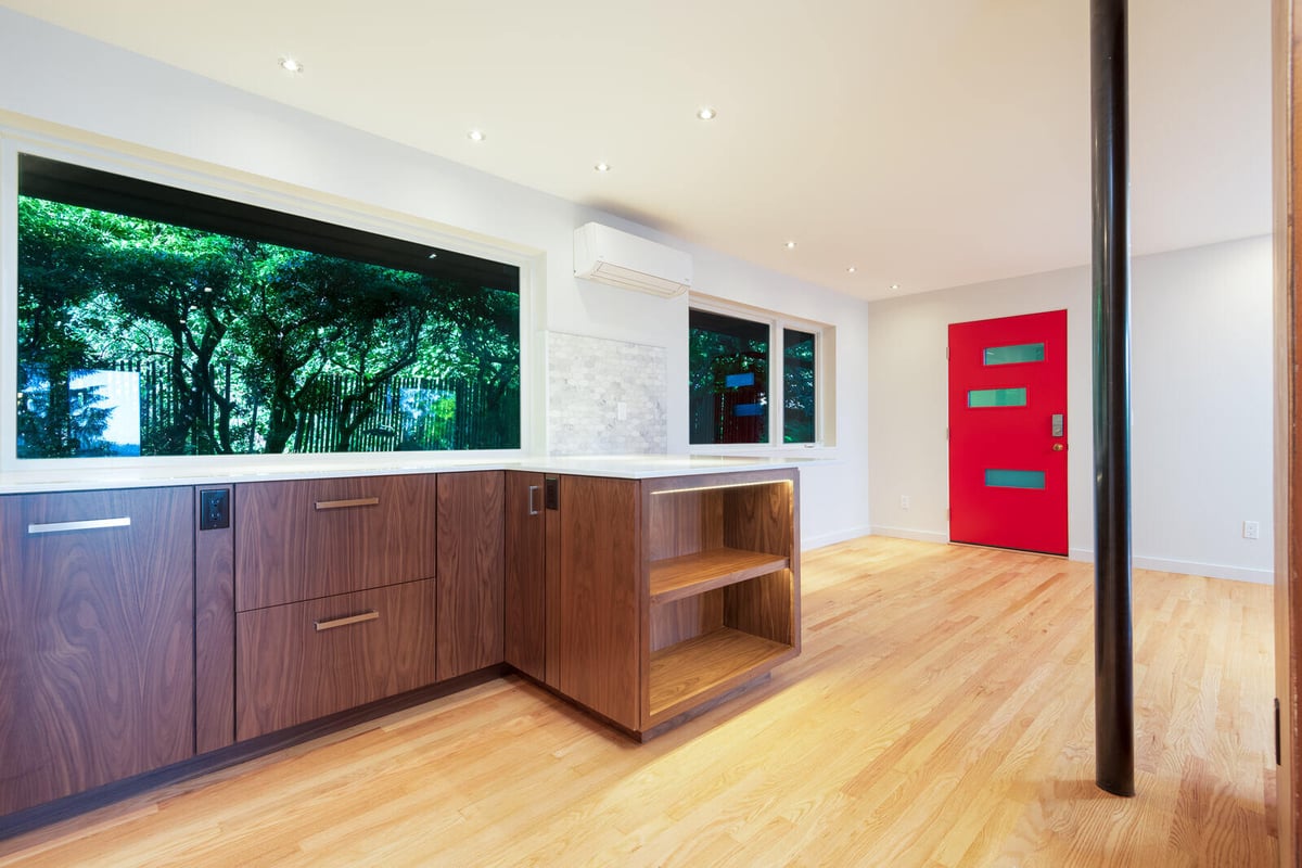 Modern kitchen featuring wood cabinetry and a bold red door, CB Construction, Seattle