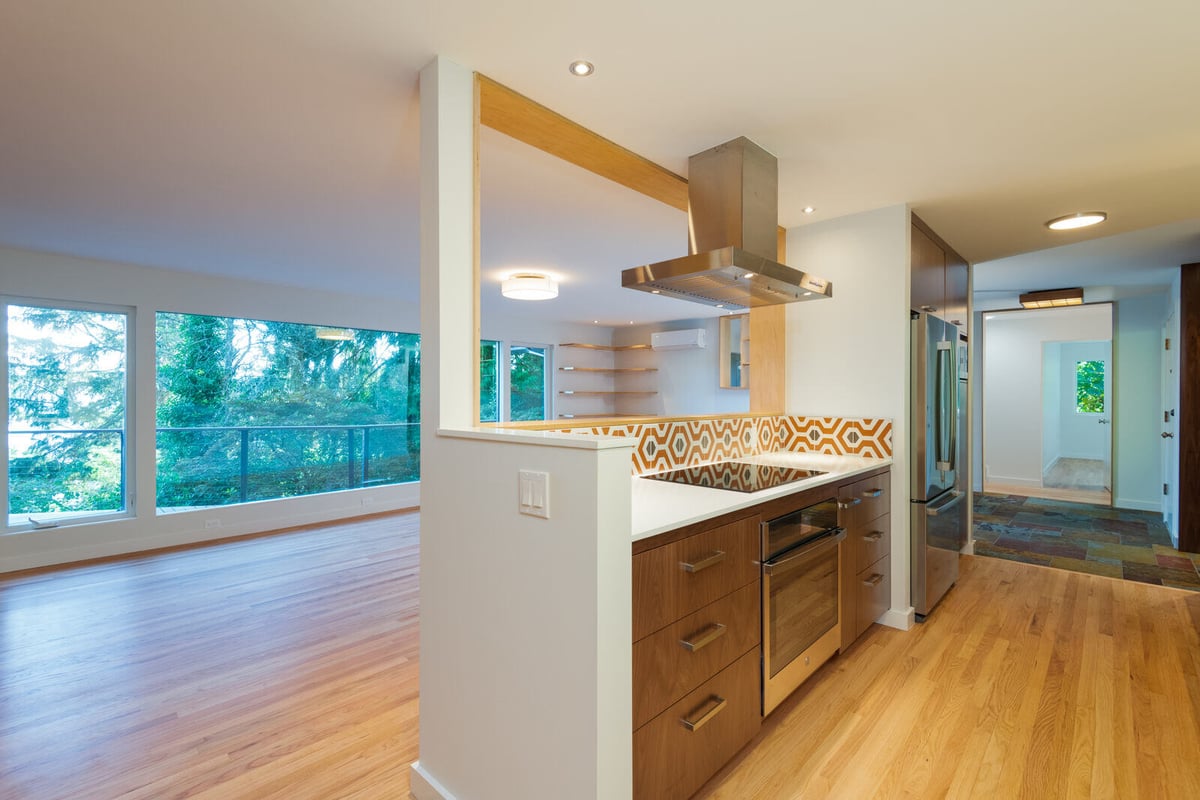 Spacious living room with stone fireplace and large patio doors, CB Construction, Seattle