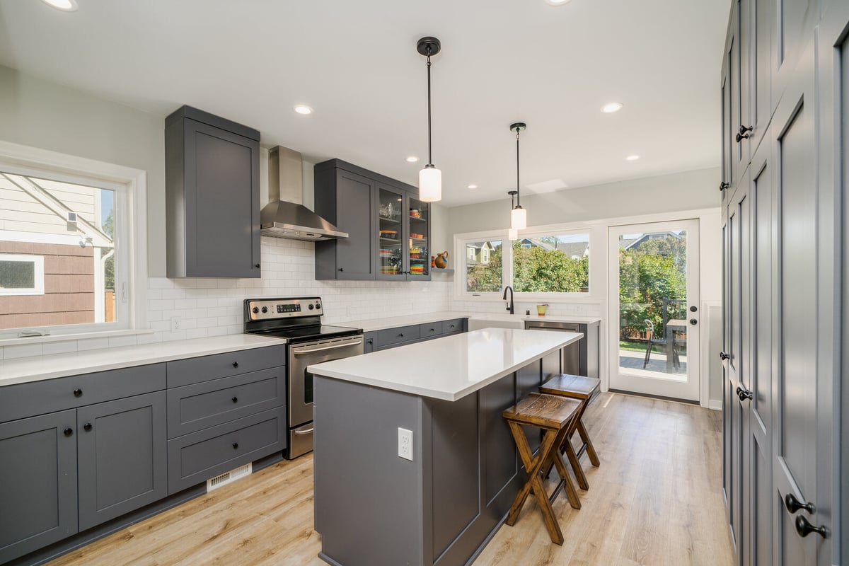 CB Constructions kitchen renovation in Seattle with grey cabinetry, stainless steel appliances, and a large island