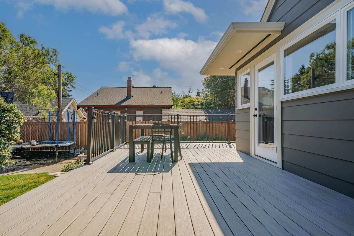 Seattle backyard deck remodel by CB Construction featuring a dining table and outdoor railing