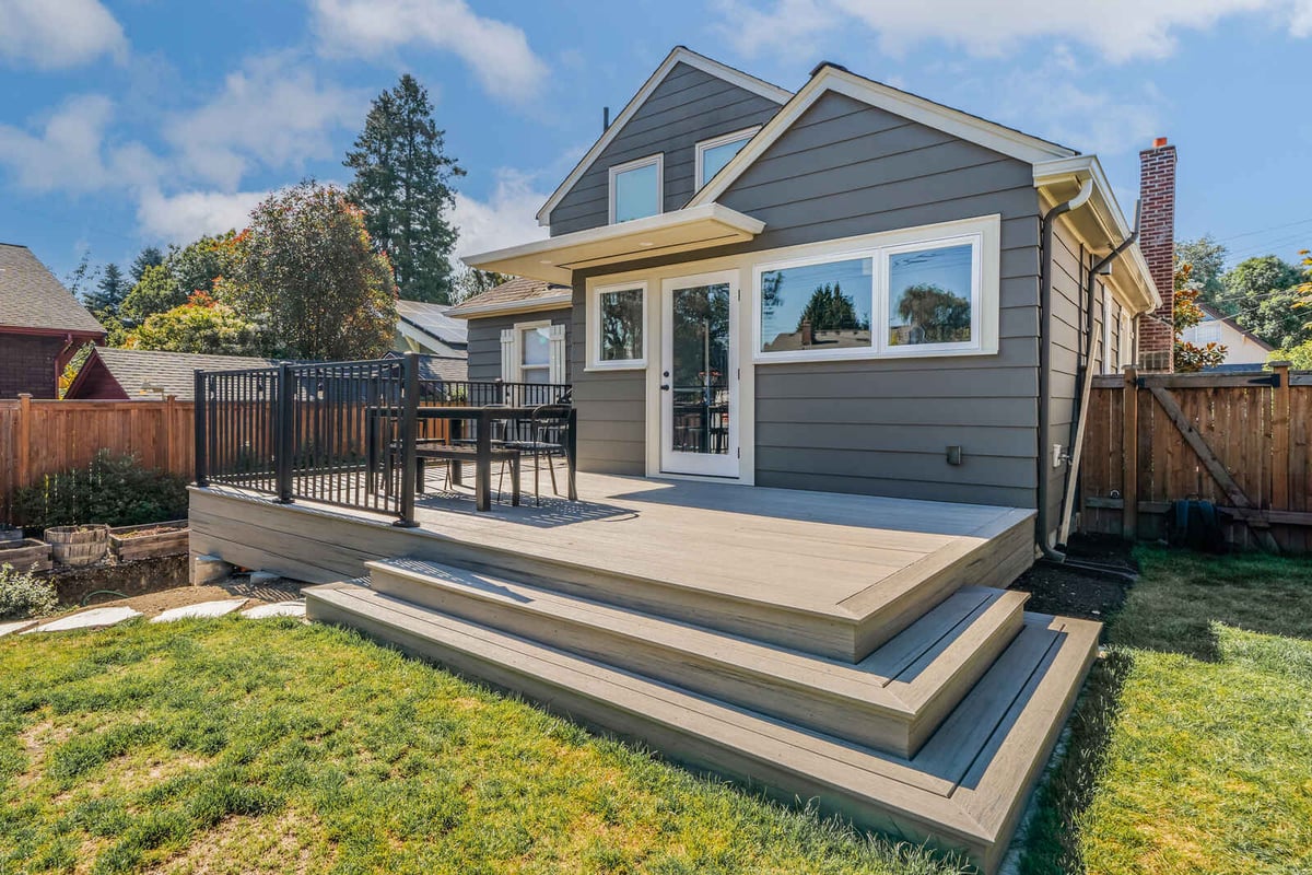 Spacious backyard deck in Seattle remodeled by CB Construction with steps and outdoor seating