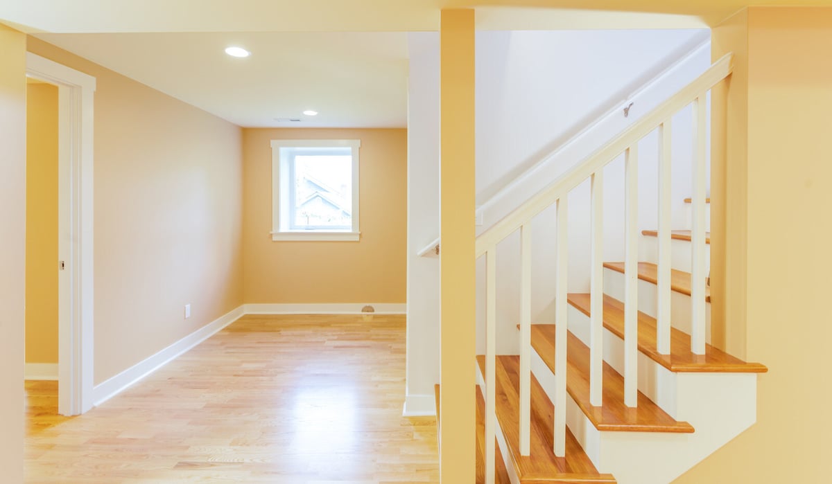 Staircase leading to a remodeled basement in Seattle, featuring light wood flooring, by CB Construction