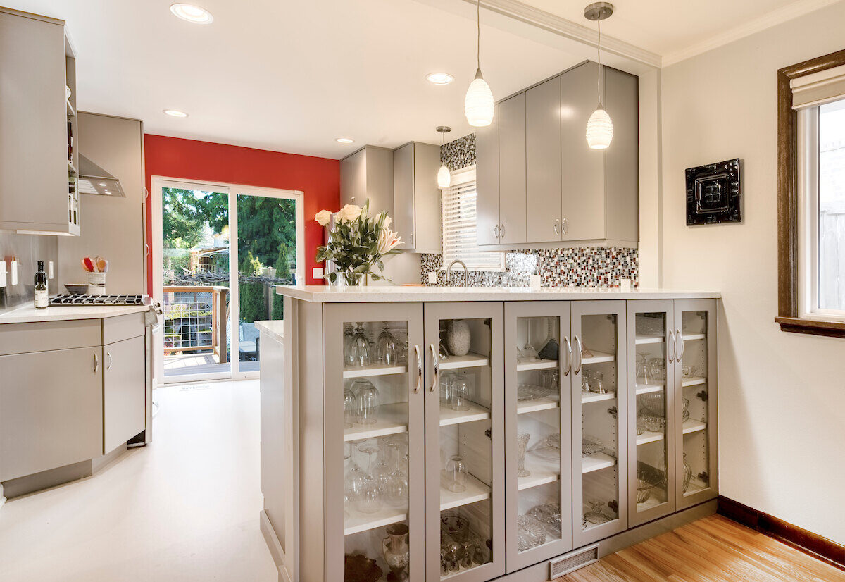 A modern kitchen remodel with light gray cabinets and red accent wall, completed by CB Construction in Seattle