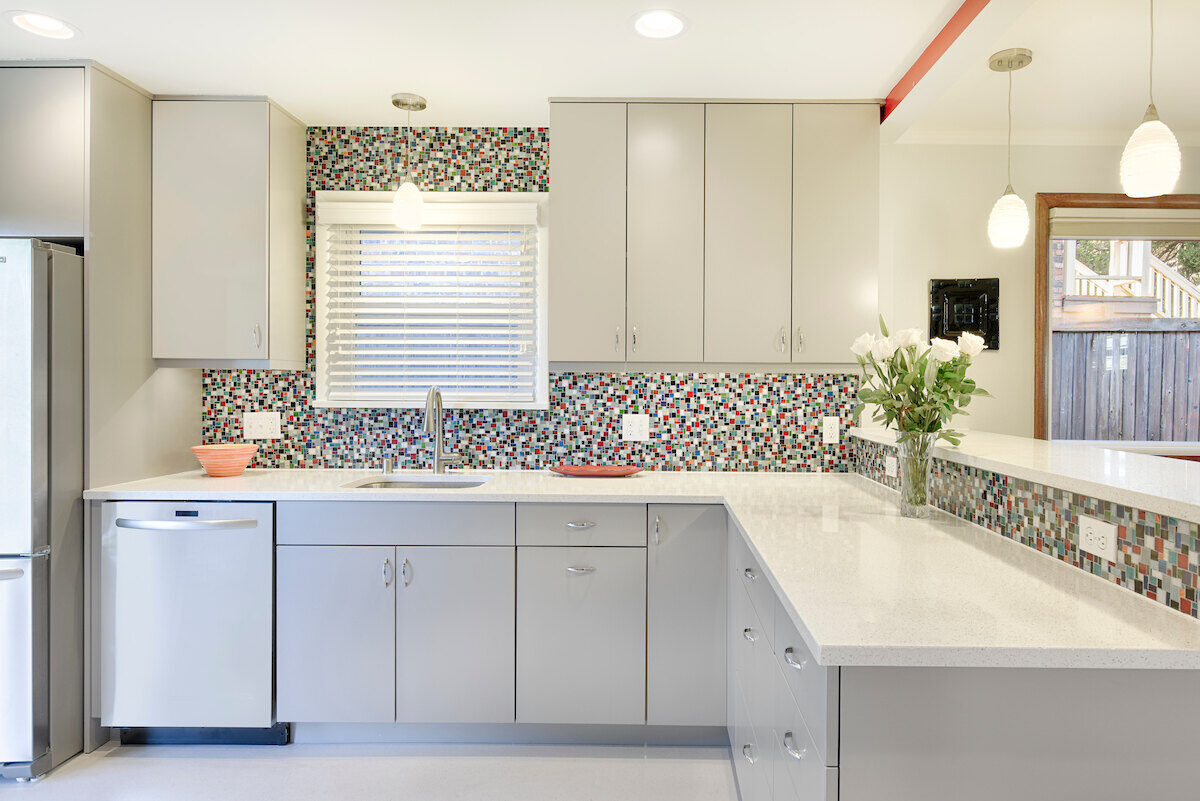 Contemporary kitchen with mosaic tile backsplash and white countertops, renovated by CB Construction in Seattle