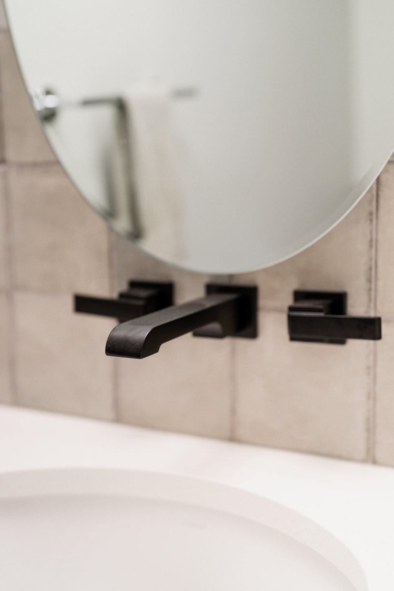 Black matte faucet detail against a tiled wall in a Seattle ADU bathroom remodel by CB Construction