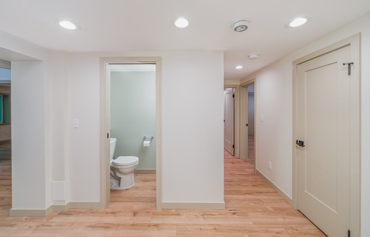 Bright hallway in a remodeled Seattle basement ADU by CB Construction, leading to a modern bathroom