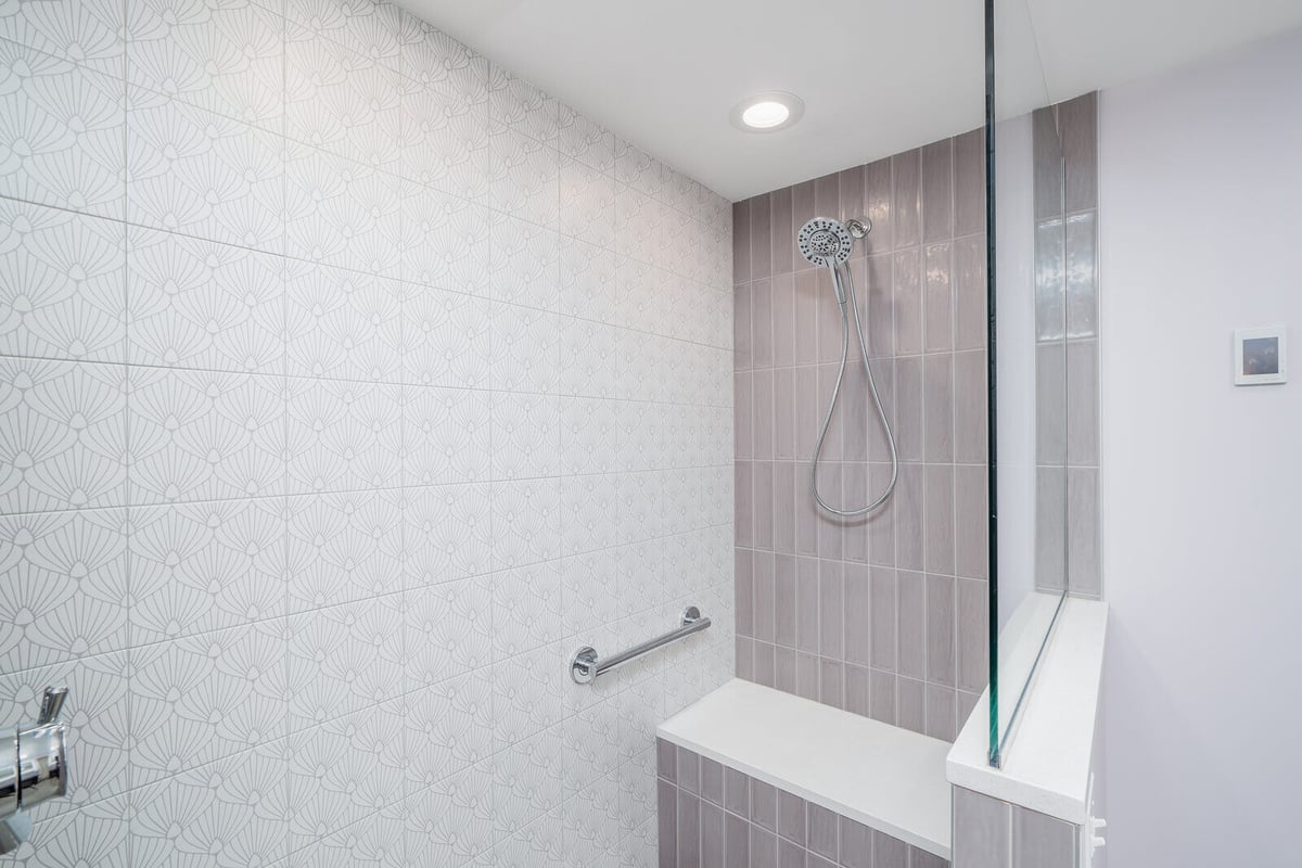 Close-up of tiled shower wall with built-in seating in a Seattle basement ADU renovation by CB Construction