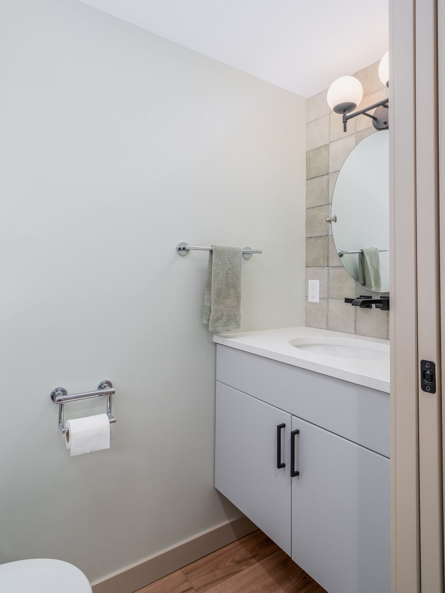 Compact bathroom in a Seattle ADU, featuring modern fixtures and a sleek vanity, remodeled by CB Construction