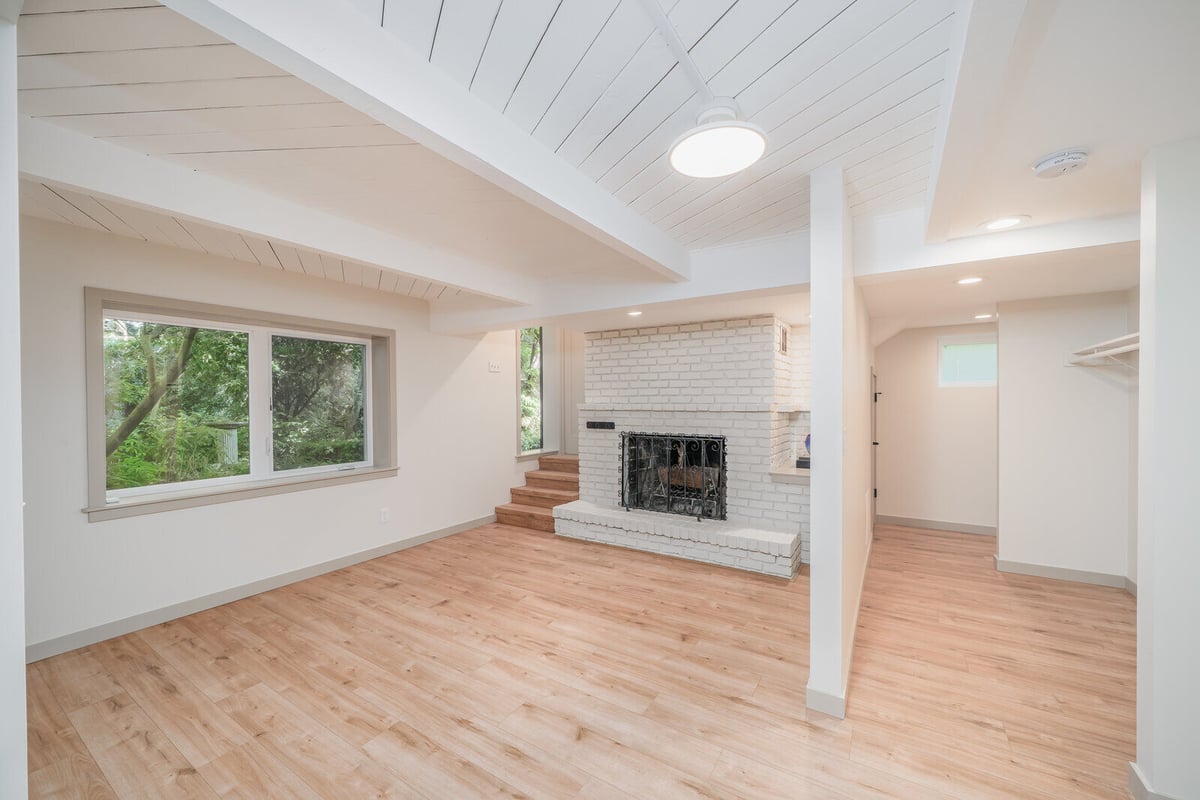 Modern basement ADU in Seattle featuring a white brick fireplace, remodeled by CB Construction