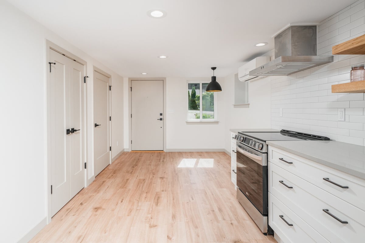 Modern kitchen in a Seattle ADU with white cabinetry and stainless steel appliances by CB Construction