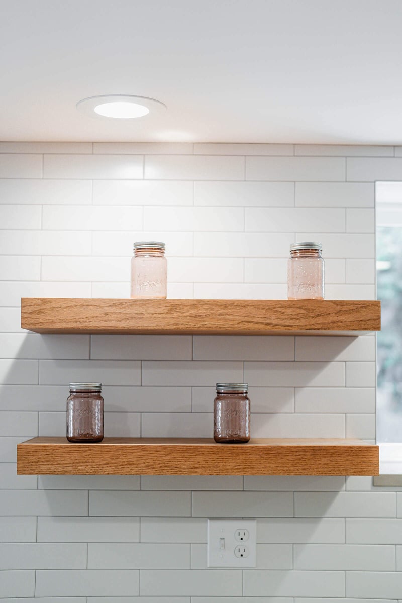 Wooden floating shelves with mason jars in a remodeled Seattle ADU kitchen by CB Construction