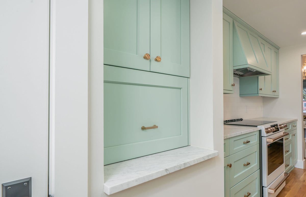 Built-in cabinetry with mint green finish in a remodeled Seattle kitchen by CB Construction