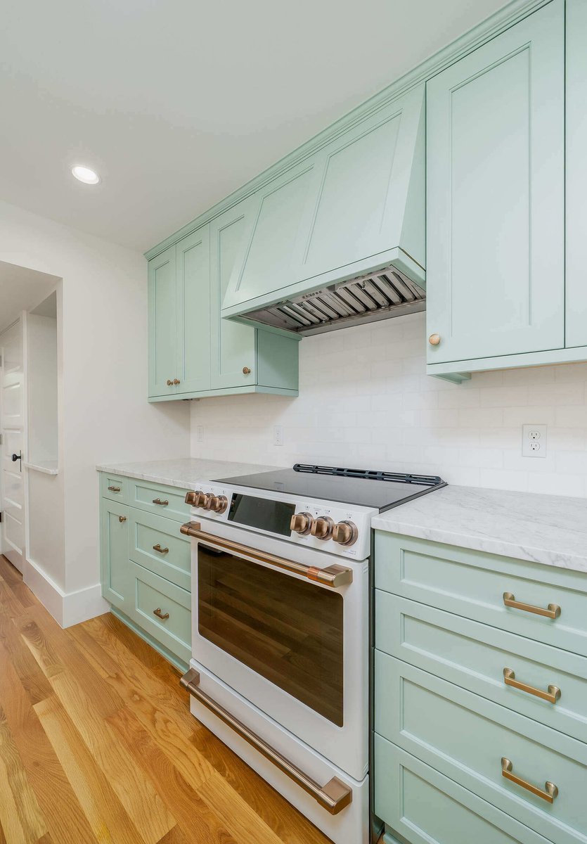 Custom kitchen design with mint green range hood and cabinetry in Seattle by CB Construction