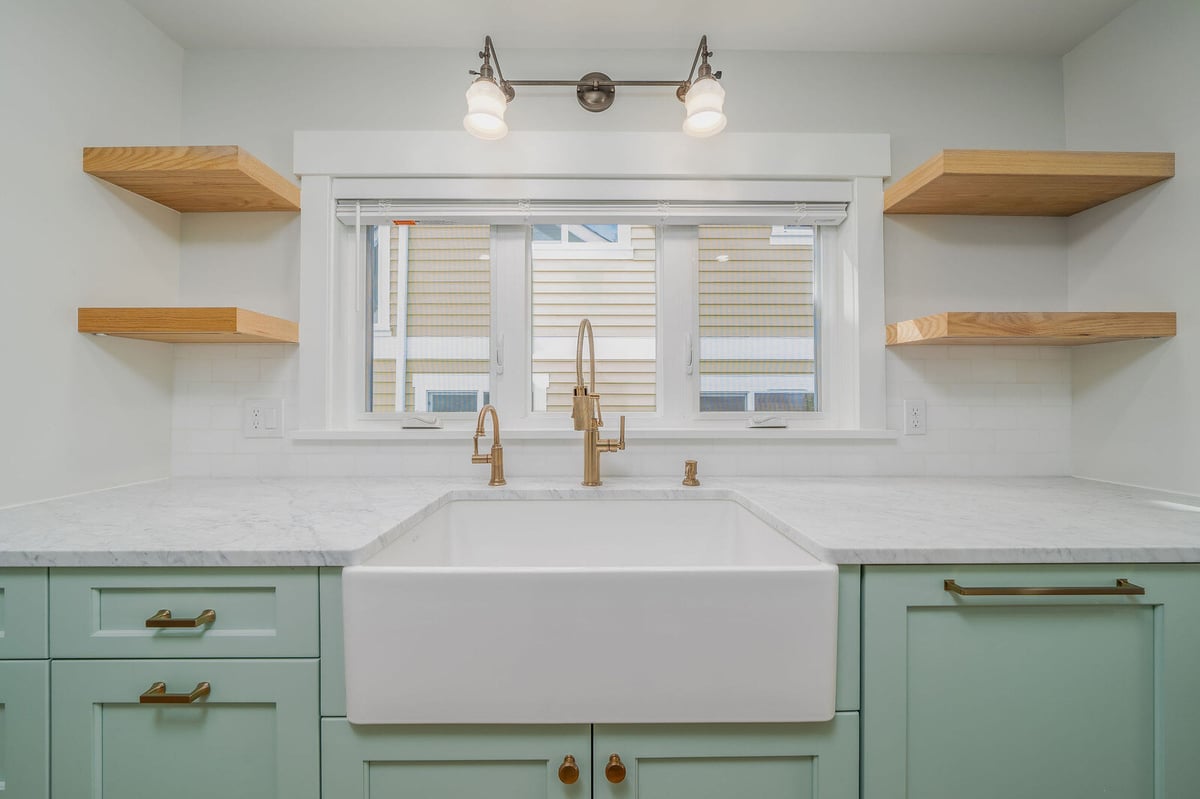 Custom kitchen remodel in Seattle with deep farmhouse sink and marble countertops by CB Construction