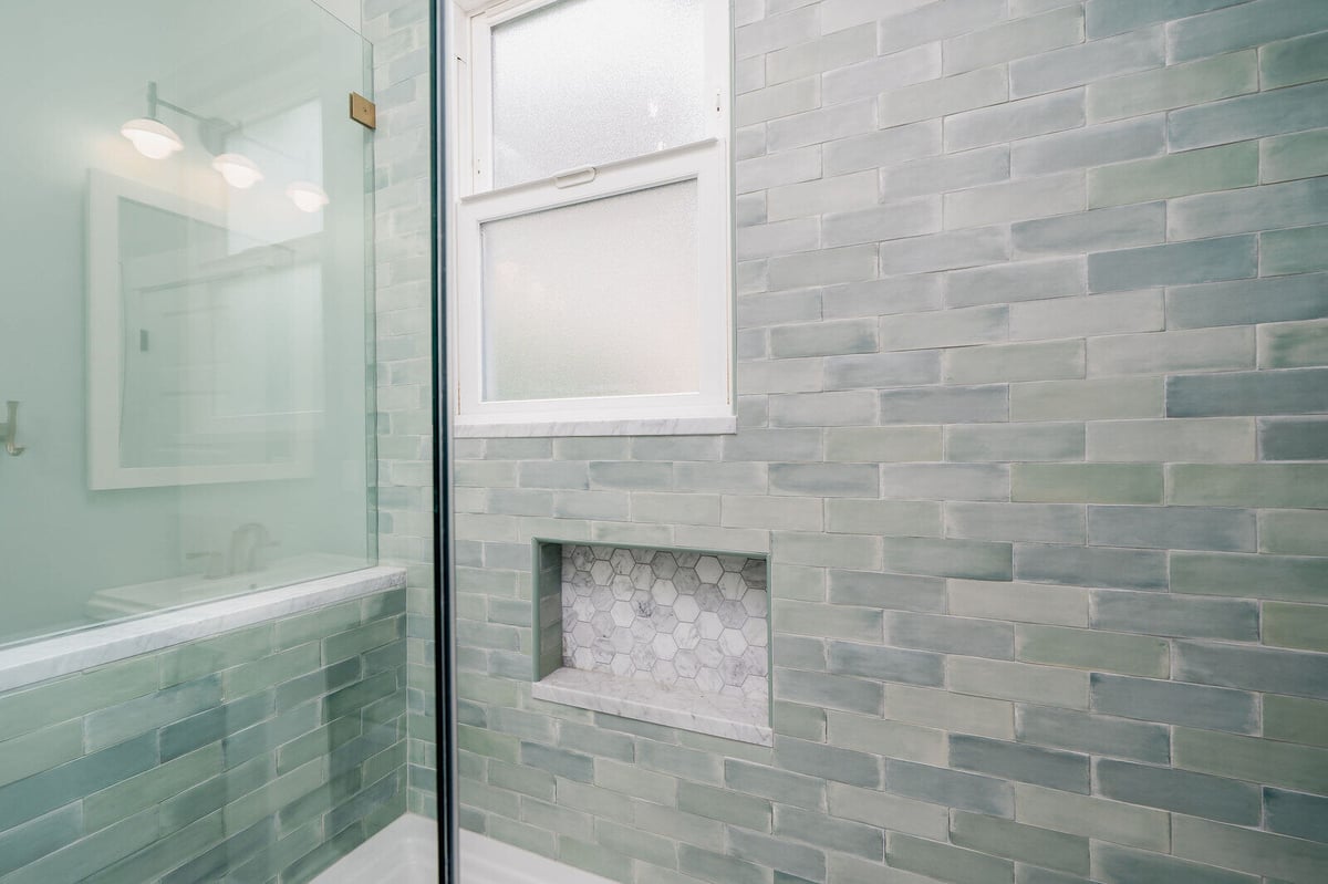 Modern bathroom vanity and mirror with brass accents in a bathroom remodel by CB Construction, Seattle