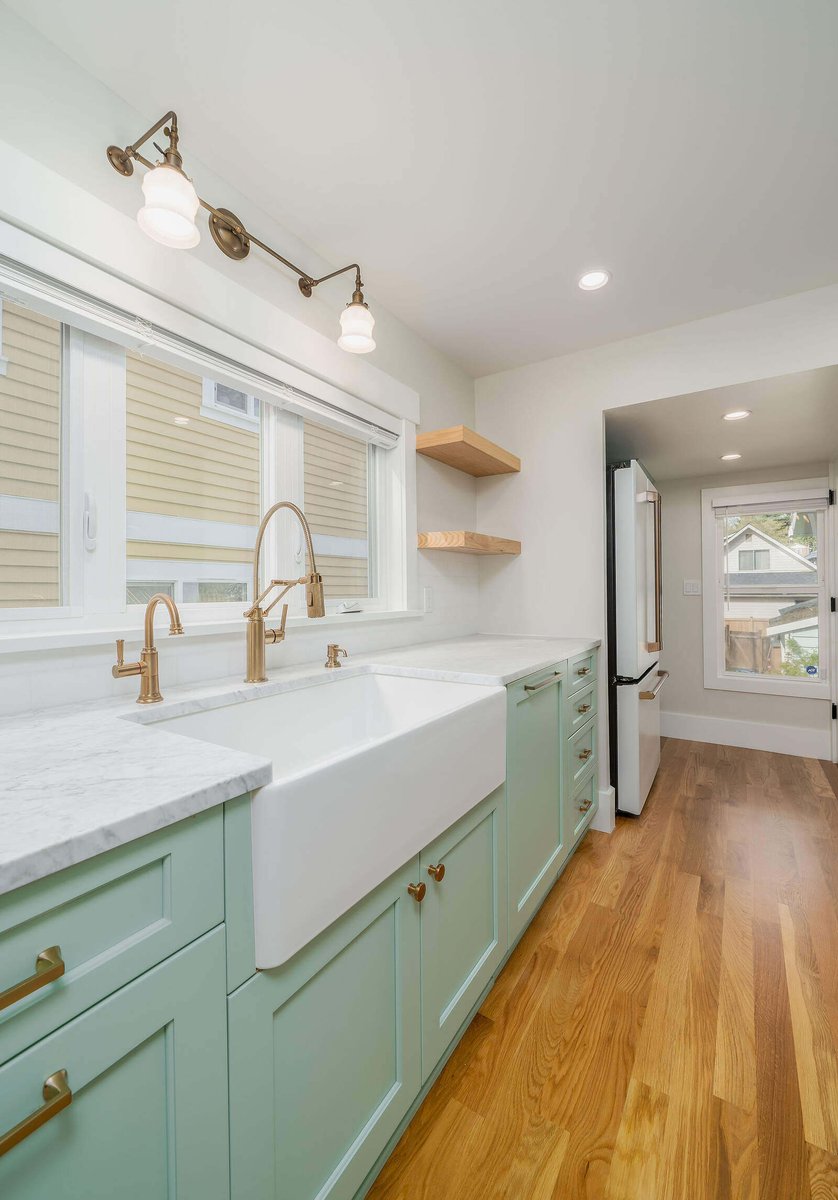 Seattle kitchen remodel featuring a farmhouse sink and brass fixtures by CB Construction