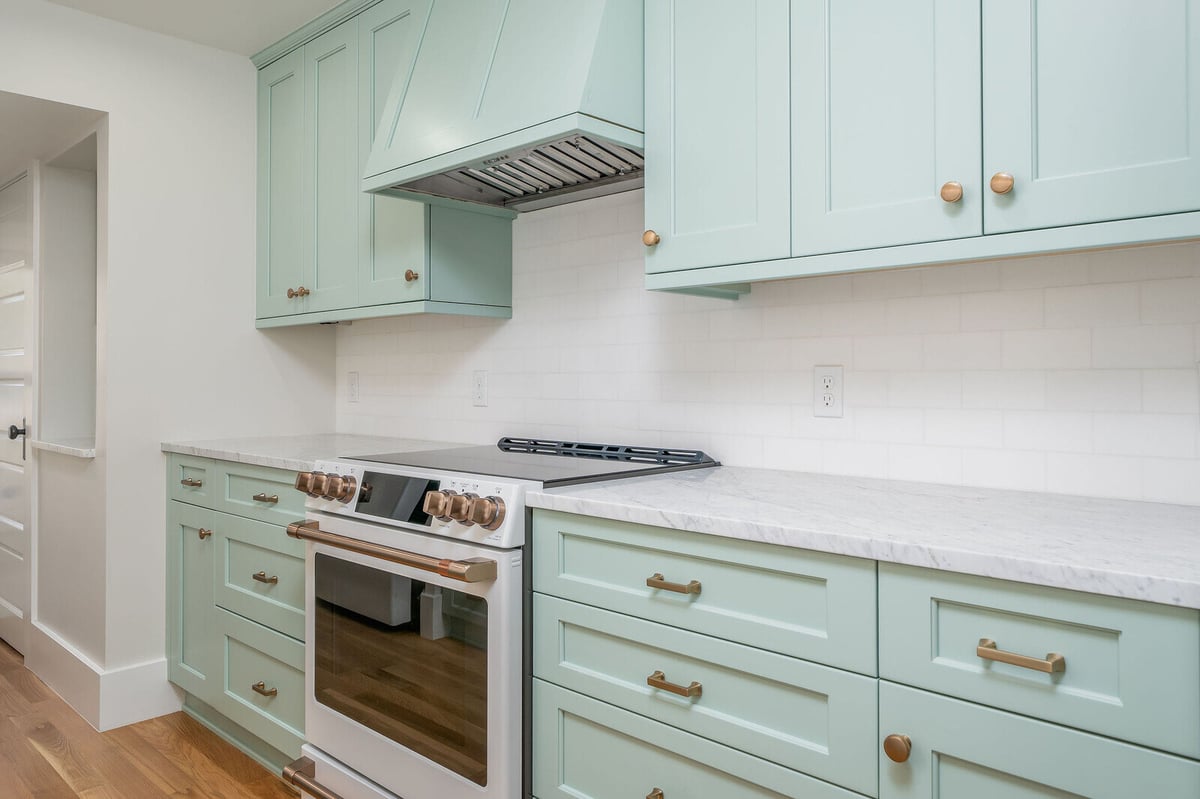 Seattle kitchen remodel with mint green cabinetry and a modern stovetop by CB Construction