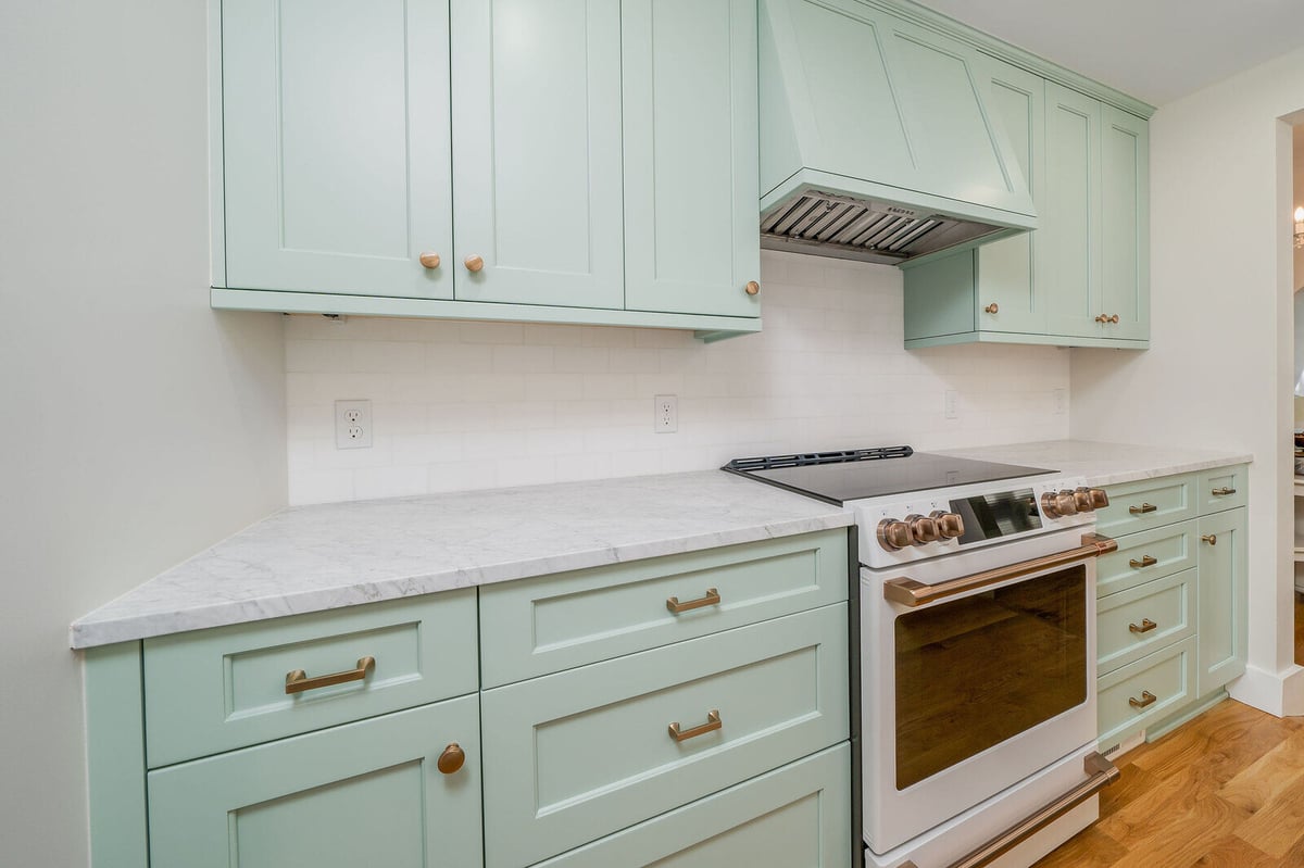 Stylish kitchen renovation in Seattle with mint green cabinets and a modern range by CB Construction