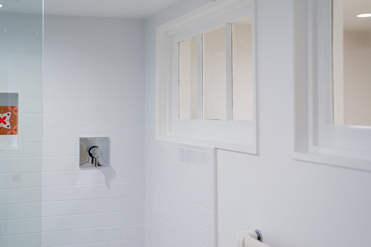 Bright, tiled shower area with large window in a Seattle basement remodel by CB Construction