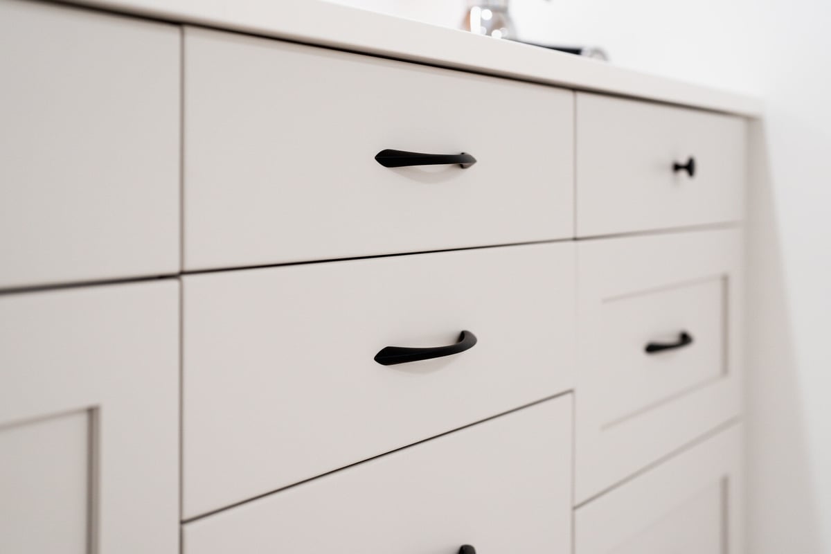Close-up of white cabinetry drawers in a basement remodel by CB Construction, Seattle