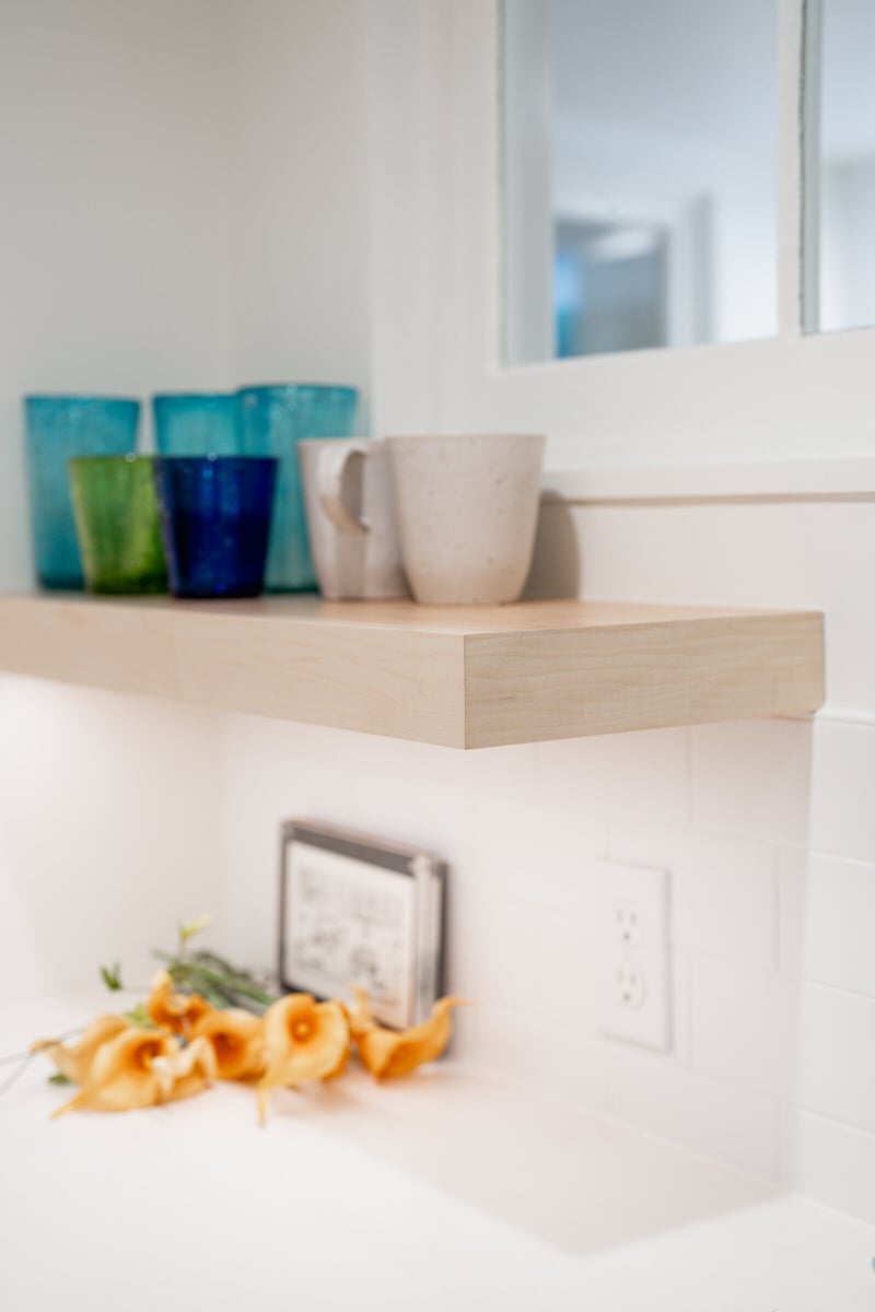Floating shelf with colorful decor above a white countertop in a CB Construction basement project, Seattle